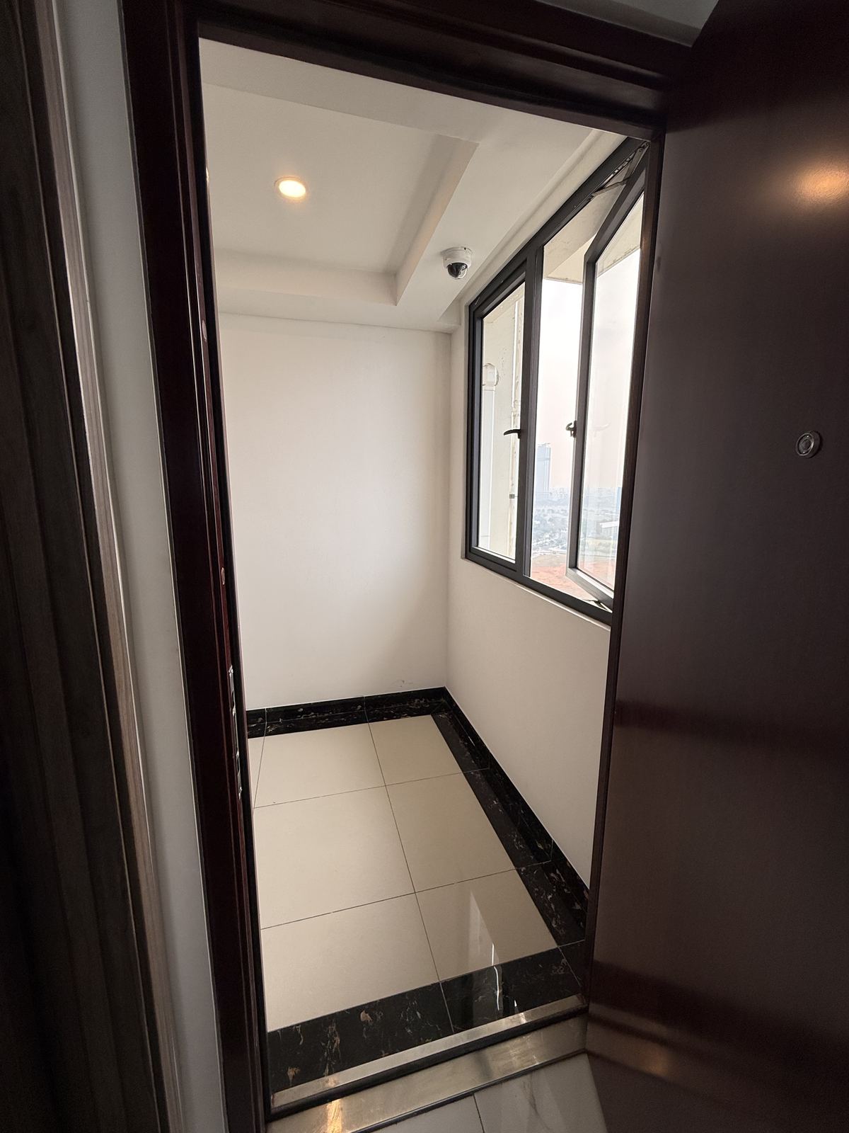 Ujung koridor lantai 21 Tower Kensington di depan pintu unit